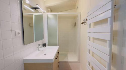 een witte badkamer met een wastafel en een spiegel bij Maison de village en 2 parties in Saint-Clément-des-Baleines