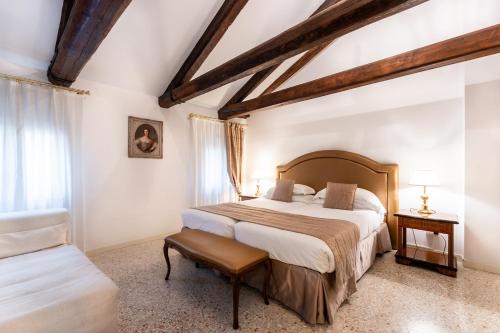 - une chambre avec un grand lit et une chaise dans l'établissement San Teodoro Palace - Luxury Apartments, à Venise