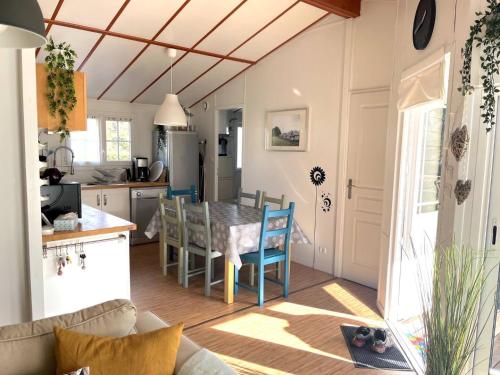 a kitchen and living room with a table and chairs at Chalet au bord du Lac de Guerlédan in Caurel