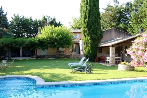 uma casa com um quintal com uma piscina em Villa de 3 chambres avec piscine privee jardin clos et wifi a Althen des Paluds em Althen-des-Paluds