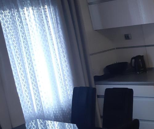 巴尼亞盧卡的住宿－Apartman Anastasija，厨房设有窗户,配有桌椅