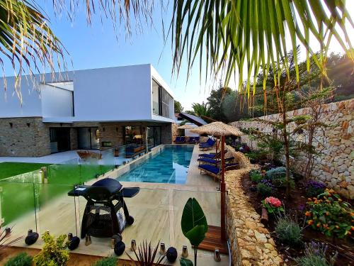 une villa avec une piscine et une maison dans l'établissement Mitjana's House, à Cala Galdana