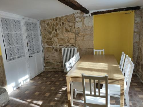 comedor con mesa de madera y sillas blancas en La antigua, en Villarcayo