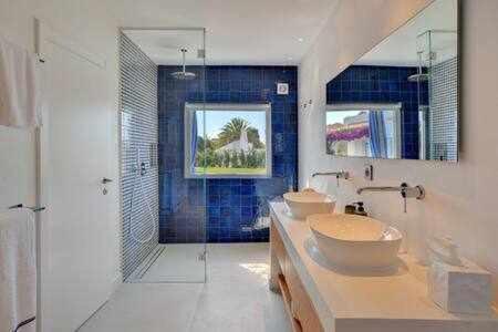 een badkamer met 2 wastafels en een douche bij Luxuosa Villa Miramar Carvoeiro in Carvoeiro