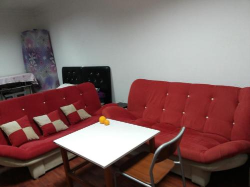 a living room with a red couch and a table at ROOMS AND APARTMENTS center of Antalya, beach, old town in Antalya