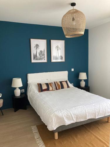 a bedroom with a large white bed with blue walls at CAZAM Paris Saint Ouen in Saint-Ouen