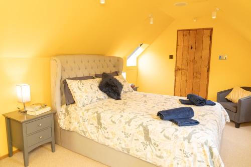 un gato sentado en una cama en un dormitorio en Mattie's Loft en Bletchingley