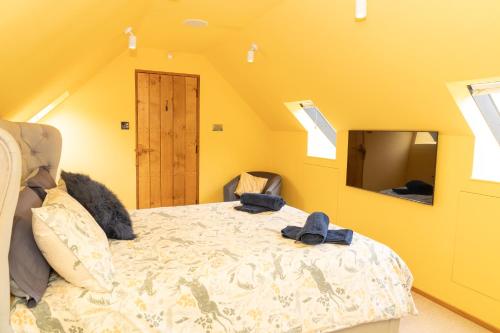 a bedroom with a bed and a yellow wall at Mattie's Loft in Bletchingley