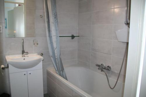 La salle de bains est pourvue d'une baignoire, d'un lavabo et d'une douche. dans l'établissement Lamsoor 2A*, à Nieuwvliet