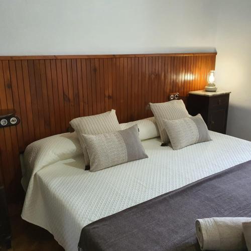 Elle comprend un grand lit avec des draps et des oreillers blancs. dans l'établissement Agroturismo Son Torrat Apartment Es Moli, à Petra