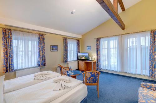 a hotel room with two beds and a television at Haus Seeblick Hotel Garni & Ferienwohnungen in Zinnowitz
