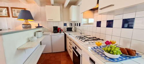a kitchen with a counter with a bowl of fruit on it at Petite maison de village avec étage in La Couarde-sur-Mer