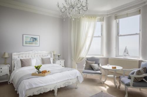 a white bedroom with a bed and a table and chairs at Harbour Heights by Bloom Stays in Folkestone