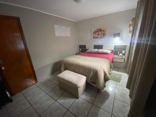 a small bedroom with a bed and a stool at Casa Olivia in Canela