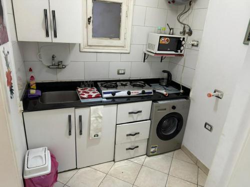 een kleine keuken met een wastafel en een wasmachine bij Delta Sharm Apartment 156 flat 102 in Sharm El Sheikh