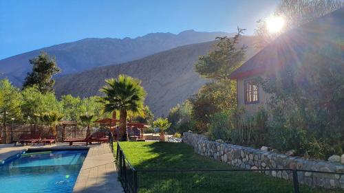 a house with a swimming pool with mountains in the background at Cabañas Las Gredas SPA Pisco Elqui in Pisco Elqui