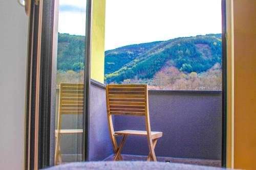 two chairs sitting on a balcony with a view at Casa de Campo Vale do Ceira in Góis