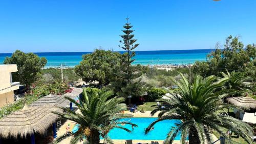 een uitzicht op een resort met een zwembad en de oceaan bij Dar Oguz in Ḩammām al Ghazzāz