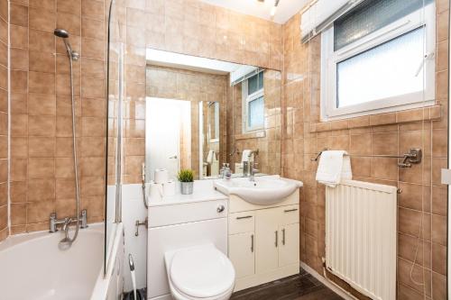 a bathroom with a toilet and a sink and a tub at Gorgeous 2BDR Flat in Shoreditch in London