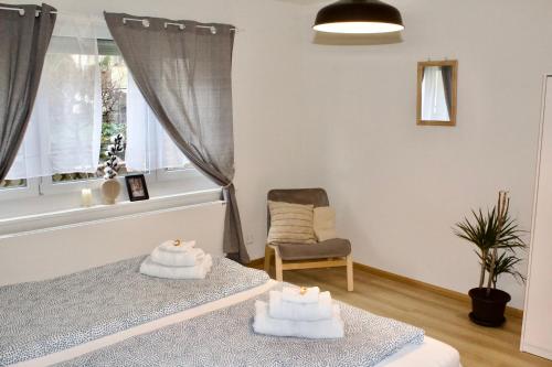 a bedroom with two beds and a chair and a window at Apartments zum Bühlhof (Alfred) in Zurich