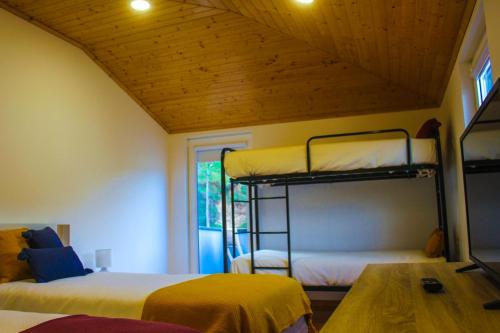 a room with two bunk beds and a table at Casa de Campo Vale do Ceira in Góis