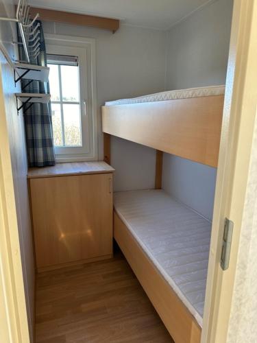 a small room with two bunk beds and a window at Duinviool in Nes