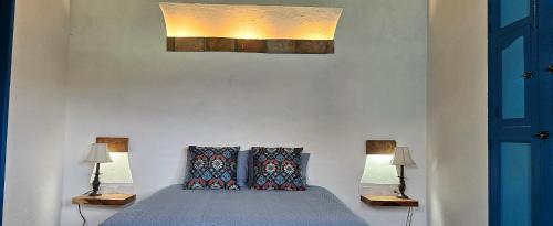 a bedroom with a bed with two pillows at Casa Luna in Jericó