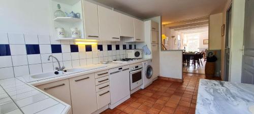 a white kitchen with a sink and a dishwasher at Maison de pays avec étage in La Couarde-sur-Mer