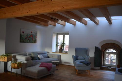 a living room with a couch and two chairs at Ferienwohnung Hofgut in Momlingen