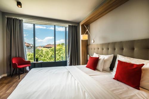 um quarto com uma cama grande e almofadas vermelhas em Up Hotel Budapest em Budapeste