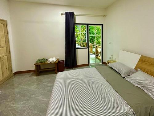 a bedroom with a large bed and a window at Nasreenuvilla in Fuvahmulah
