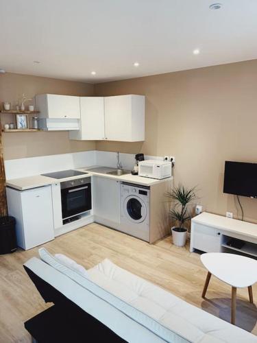 une cuisine avec des armoires blanches et une laveuse et une sécheuse dans l'établissement Rousquille: Patio au RDC d'une maison calme, à Port-Vendres