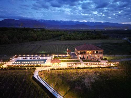 una vista aérea de un gran edificio en un campo por la noche en Chateau Vartsikhe en Varts'ikhe