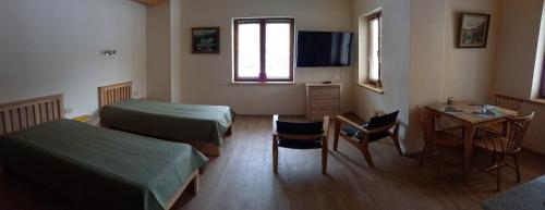 a hospital room with two beds and a table and chairs at S Neries 19 apartamentai su parkingu in Šiauliai