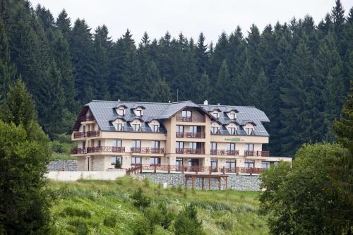 a large building on top of a hill with trees at Hotel Green in Dolný Kubín