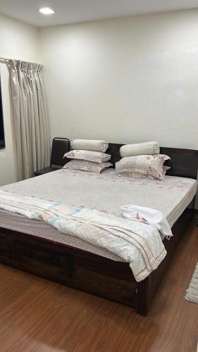 een slaapkamer met een groot bed met kussens erop bij Rungta home sweet home in Calcutta