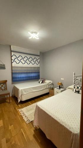 a bedroom with two beds and a window at Apartamento Saudade in Cambados