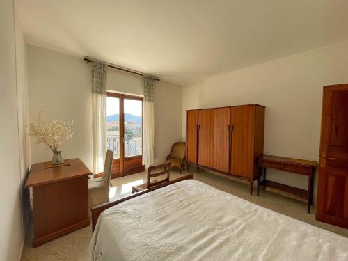a bedroom with a bed and a desk and a window at Villa Les Oliviers proche centre Porto-Vecchio in Porto-Vecchio