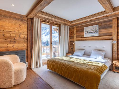 a bedroom with a bed and a chair and a window at Appartement luxe 4 pièces + studio, terrasse Sud, centre Val-d'Isère, 2023, 8 personnes - FR-1-694-149 in Val dʼIsère