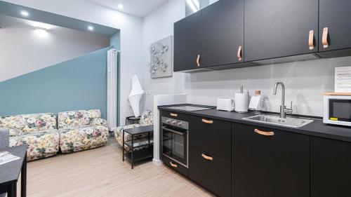 a kitchen with a sink and a couch in a room at Italianway - Jommelli 44 in Milan