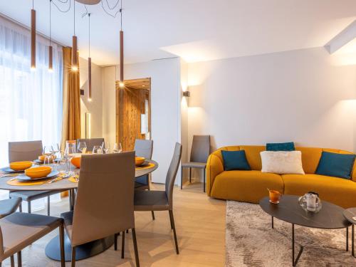 un salon avec une table et un canapé jaune dans l'établissement Appartement raffiné avec accès direct aux pistes, wifi et parking 2 places - FR-1-694-346, à Val dʼIsère