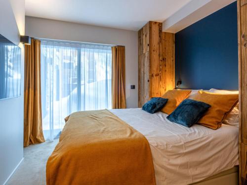 - une chambre avec un grand lit et 2 oreillers bleus dans l'établissement Appartement raffiné avec accès direct aux pistes, wifi et parking 2 places - FR-1-694-346, à Val dʼIsère