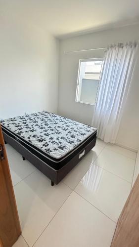 ein Schlafzimmer mit einem Bett in einem Zimmer mit einem Fenster in der Unterkunft Casa Itajubá in Barra Velha