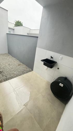 ein Bad mit einer schwarzen Tasche auf dem Boden in der Unterkunft Casa Itajubá in Barra Velha