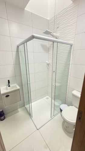 ein weißes Bad mit einer Dusche und einem WC in der Unterkunft Casa Itajubá in Barra Velha