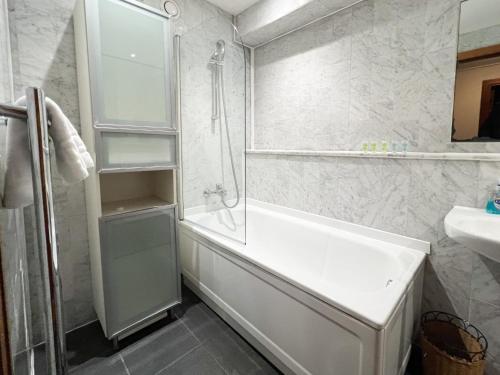 a white bathroom with a tub and a sink at 2BR Flat Historic Centre Sleeps 5 in Edinburgh