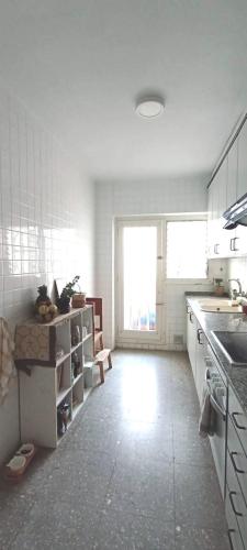 a white kitchen with a sink and a counter at Chambre charmante chez habitant in Valencia