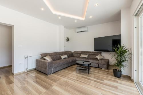 a living room with a couch and a tv at Villa Sky D 9&1 with tennis court and heated pool in Omiš
