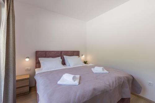 a bedroom with a bed with two towels on it at Villa Sky D 9&1 with tennis court and heated pool in Omiš
