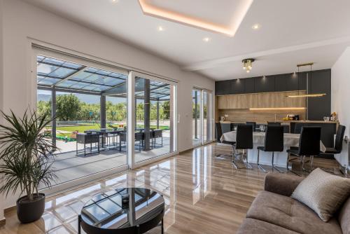 an open living room with a kitchen and a dining room at Villa Sky D 9&1 with tennis court and heated pool in Omiš